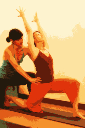 yoga teacher assisting a student